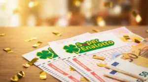 Schedine del Superenalotto su un tavolo con banconote e coriandoli dorati